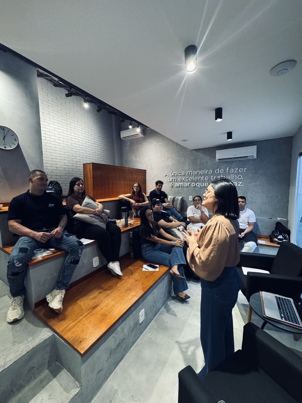 Grupo sentado em degraus acompanhando uma apresentação